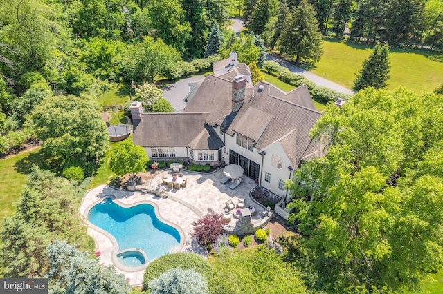 aerial view of property and surrounding area with a pool area