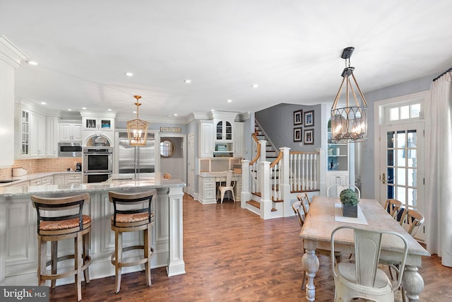 dining space featuring a chandelier, stairway, wood finished floors, and recessed lighting