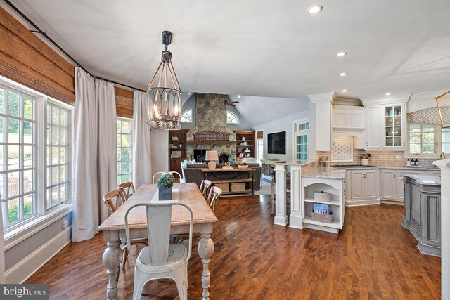 dining room with a chandelier, recessed lighting, dark wood-style flooring, vaulted ceiling, and baseboards