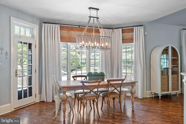 dining area with a chandelier, plenty of natural light, and wood finished floors