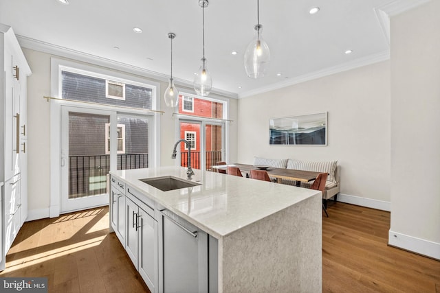 kitchen with wood finished floors, baseboards, ornamental molding, and a sink