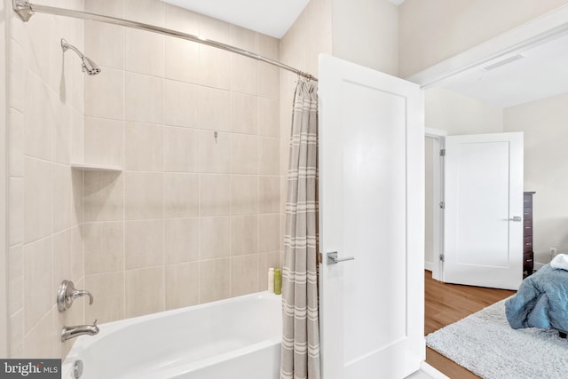 full bathroom with shower / bath combination with curtain, visible vents, and wood finished floors