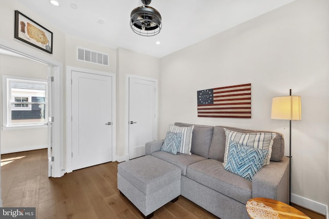living room with baseboards, visible vents, wood finished floors, and recessed lighting