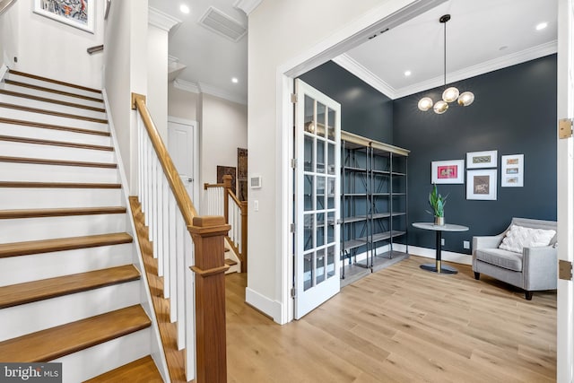 interior space featuring stairs, visible vents, light wood-style flooring, baseboards, and ornamental molding