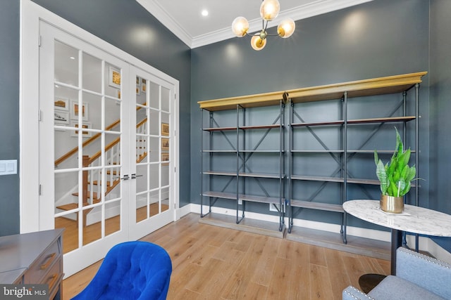 interior space featuring a chandelier, crown molding, baseboards, french doors, and wood finished floors
