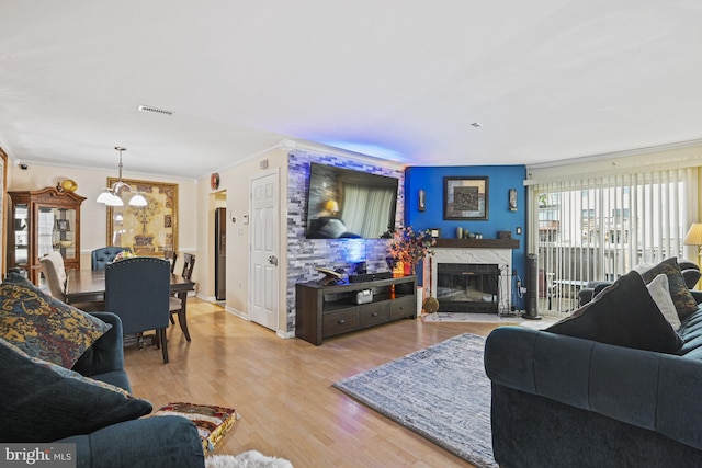 10519 Stonington Ln, Manassas, VA 20109 - living area with ornamental molding, visible vents, a fireplace, a chandelier, and light wood-style flooring
