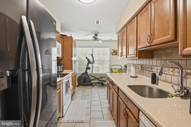 10519 Stonington Ln, Manassas, VA 20109 - kitchen featuring a sink, white appliances, brown cabinets, visible vents, and decorative backsplash