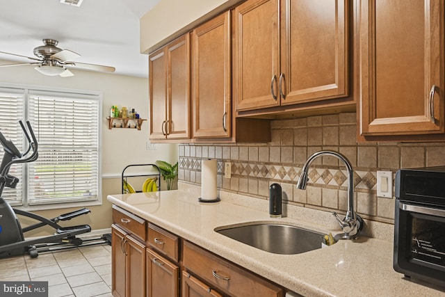 10519 Stonington Ln, Manassas, VA 20109 - kitchen with brown cabinetry, tasteful backsplash, ceiling fan, and a sink