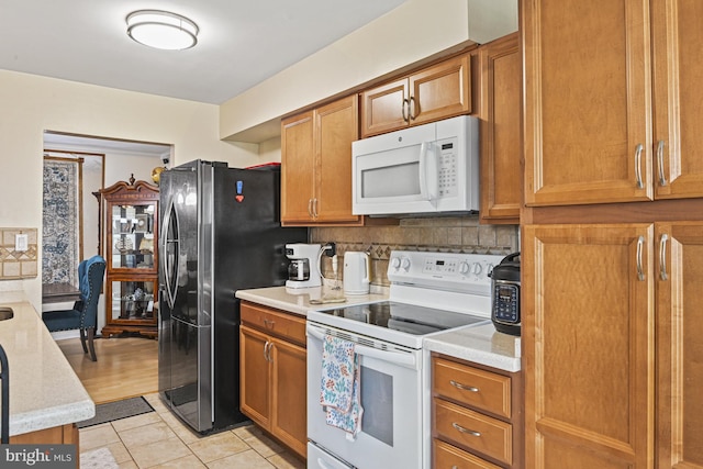 10519 Stonington Ln, Manassas, VA 20109 - kitchen with brown cabinets, white appliances, light countertops, and tasteful backsplash
