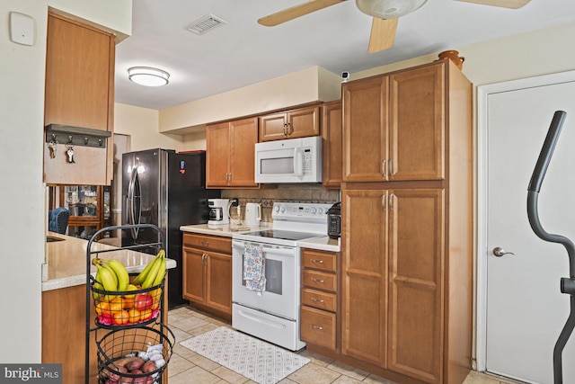 10519 Stonington Ln, Manassas, VA 20109 - kitchen with brown cabinetry, white appliances, visible vents, decorative backsplash, and a ceiling fan