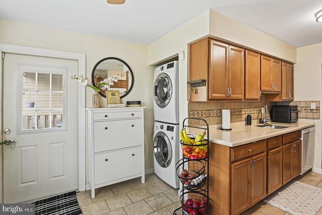 10519 Stonington Ln, Manassas, VA 20109 - washroom featuring a sink, laundry area, light tile patterned flooring, stacked washer / drying machine, and baseboards