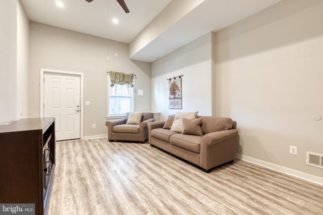 living area featuring visible vents, a ceiling fan, baseboards, and light wood-style flooring