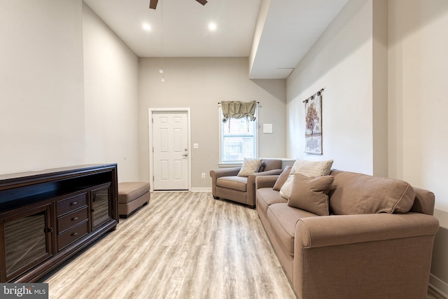 living area featuring baseboards, a ceiling fan, and light wood-type flooring