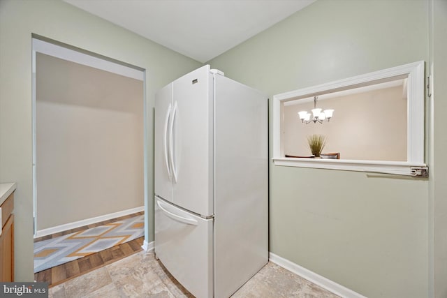 103 Debbie Ln, Phoenixville, PA 19460 - kitchen with freestanding refrigerator, baseboards, and a notable chandelier