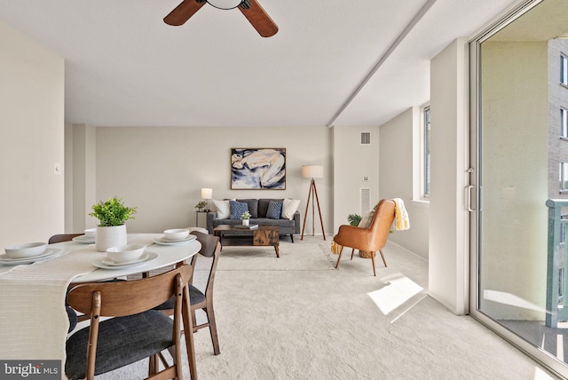 dining room with visible vents, light colored carpet, and ceiling fan