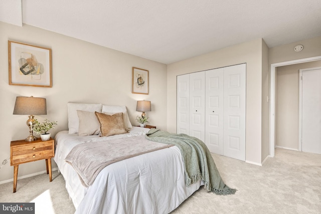 bedroom with a closet, baseboards, and light carpet