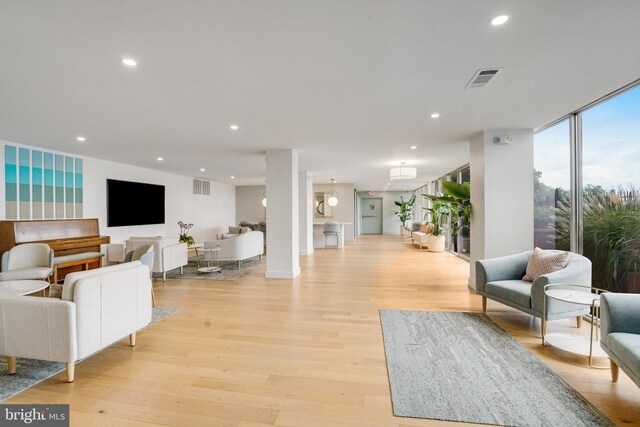 living room featuring recessed lighting, light wood-style floors, and visible vents