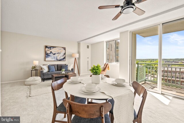 carpeted dining room featuring visible vents, a ceiling fan, and baseboards