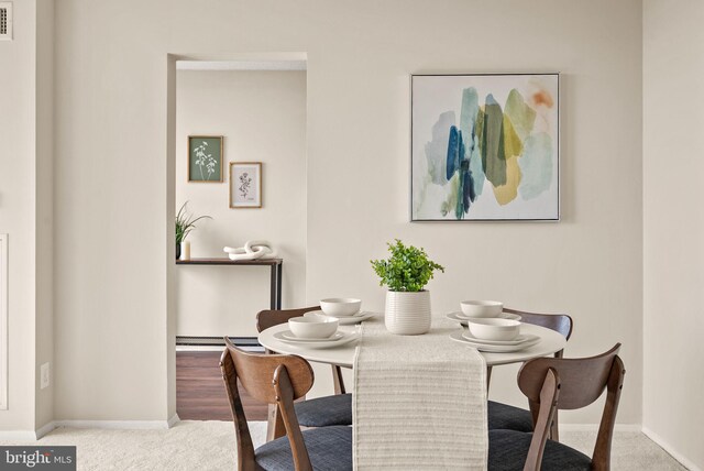 carpeted dining room with visible vents and baseboards