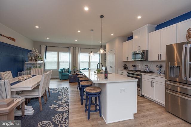12461 Coastal Marsh Dr Unit 707, Berlin, MD 21811 - kitchen with appliances with stainless steel finishes, a sink, light countertops, a kitchen island with sink, and white cabinets