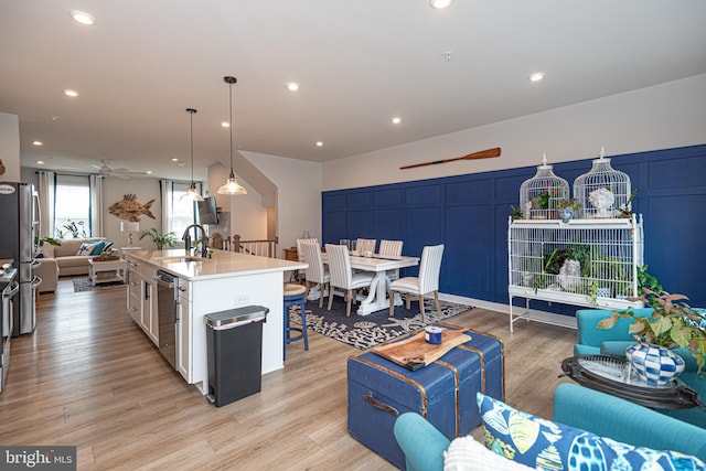 12461 Coastal Marsh Dr Unit 707, Berlin, MD 21811 - kitchen with open floor plan, ceiling fan, a sink, a breakfast bar, and light wood-style floors