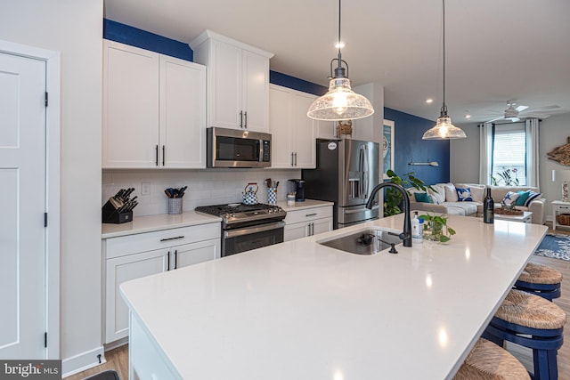 12461 Coastal Marsh Dr Unit 707, Berlin, MD 21811 - kitchen featuring stainless steel appliances, a sink, a kitchen island with sink, open floor plan, and tasteful backsplash