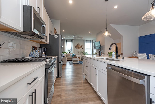 12461 Coastal Marsh Dr Unit 707, Berlin, MD 21811 - kitchen with appliances with stainless steel finishes, a sink, open floor plan, white cabinets, and backsplash