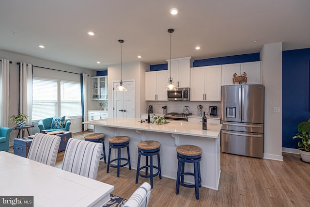 12461 Coastal Marsh Dr Unit 707, Berlin, MD 21811 - kitchen with stainless steel appliances, a sink, light wood finished floors, tasteful backsplash, and light countertops