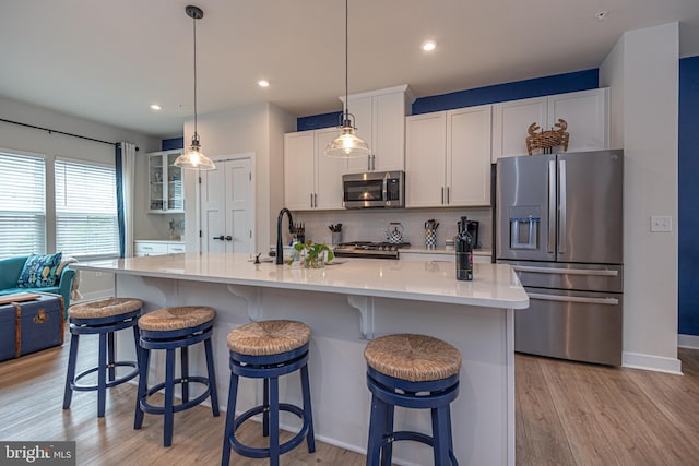 12461 Coastal Marsh Dr Unit 707, Berlin, MD 21811 - kitchen with appliances with stainless steel finishes, a sink, light wood-type flooring, white cabinetry, and backsplash
