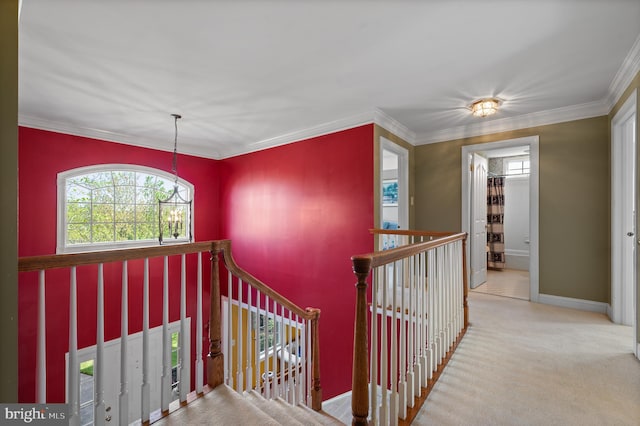 hall featuring carpet floors, baseboards, crown molding, and an upstairs landing