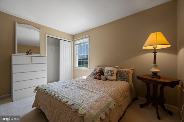 carpeted bedroom featuring baseboards and a closet