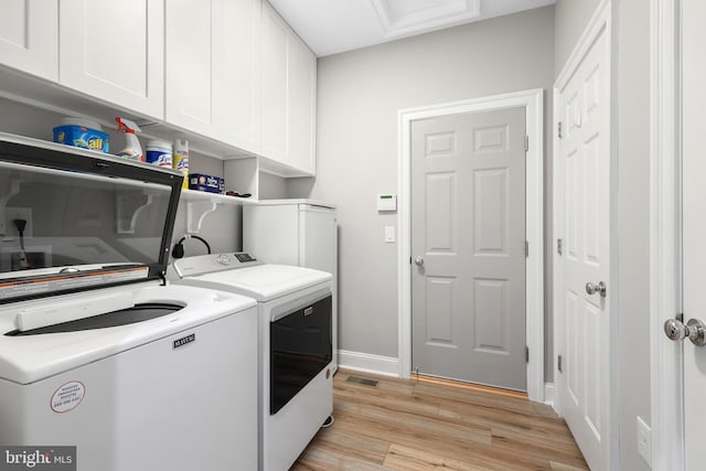 84 Battery Point Dr, Fredericksburg, VA 22406 - laundry area featuring cabinet space, separate washer and dryer, light wood finished floors, and baseboards
