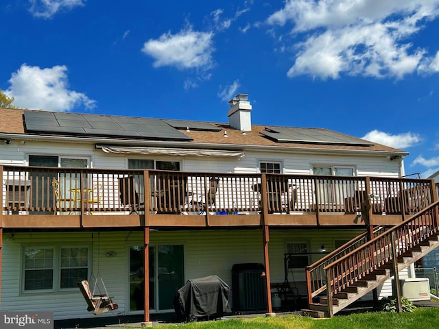 rear view of house with a chimney, central air condition unit, stairway, and a deck