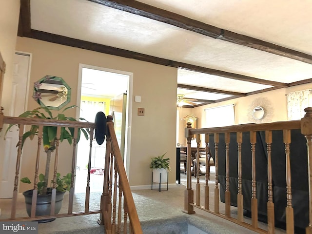 interior space featuring beam ceiling, baseboards, and carpet floors
