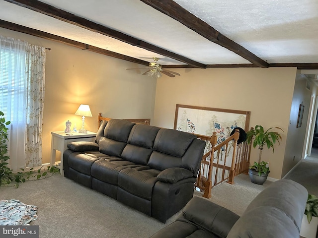 carpeted living room featuring beam ceiling, baseboards, and a ceiling fan