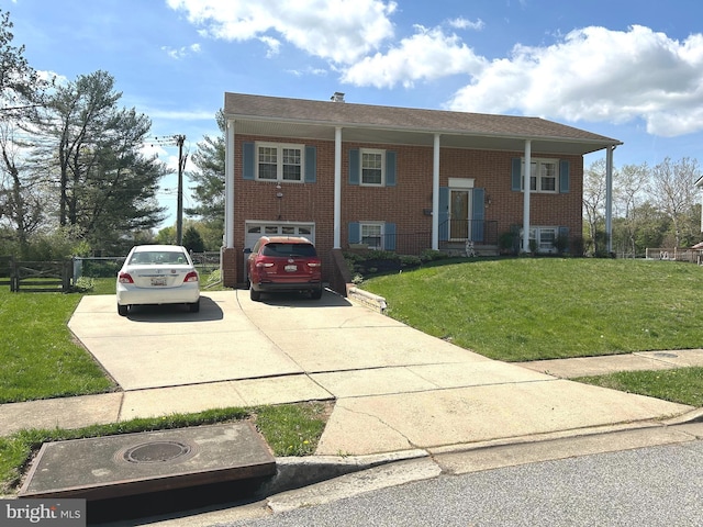 split foyer home featuring a front yard, brick siding, and driveway