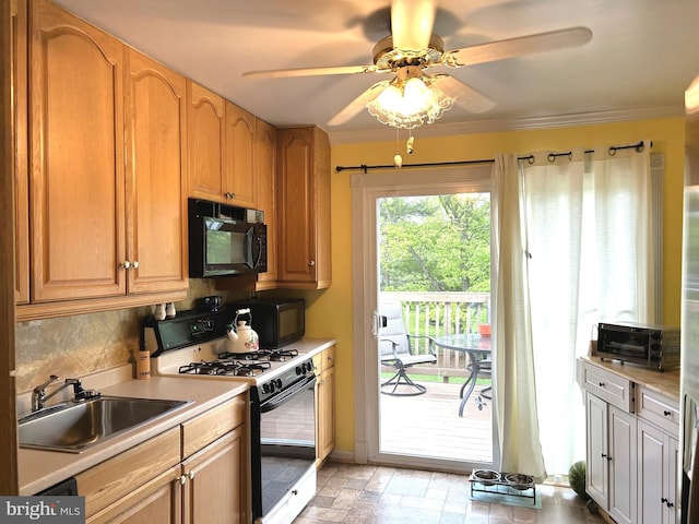 kitchen with gas range oven, ceiling fan, a sink, black microwave, and light countertops