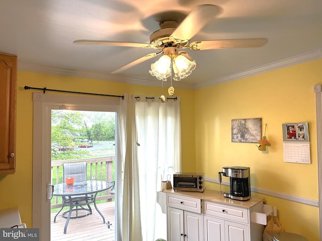 entryway featuring crown molding, a ceiling fan, and a toaster