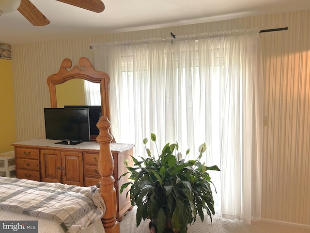 carpeted bedroom featuring baseboards, wallpapered walls, and a ceiling fan