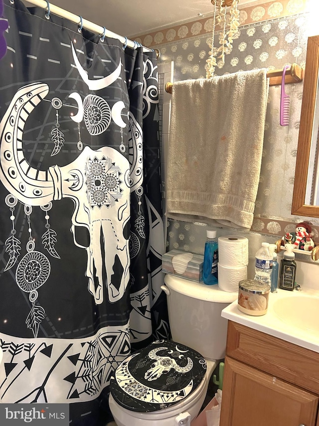 bathroom featuring toilet, vanity, wallpapered walls, and a shower with shower curtain