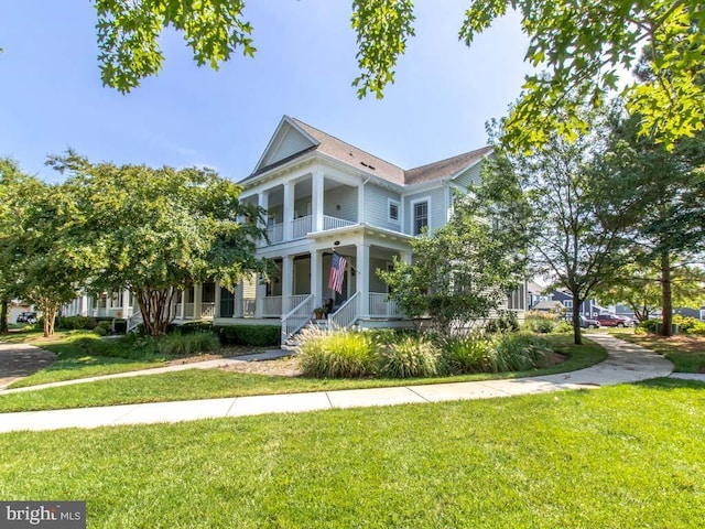 greek revival inspired property with covered porch, a balcony, and a front yard