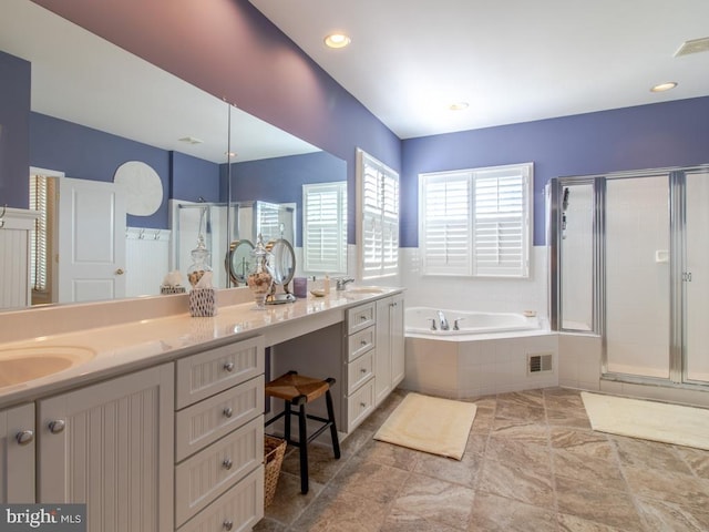 full bath featuring a bath, a sink, double vanity, visible vents, and a shower stall