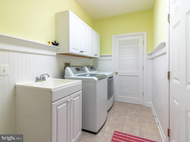 laundry room with cabinet space, independent washer and dryer, light tile patterned flooring, and wainscoting