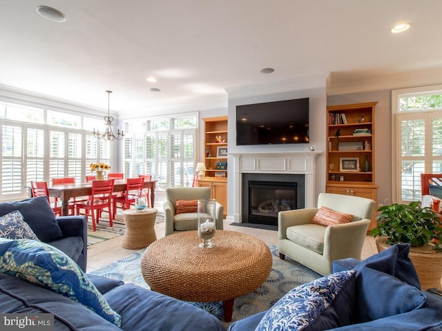 living area featuring a fireplace with flush hearth, ornamental molding, a notable chandelier, and light tile patterned floors
