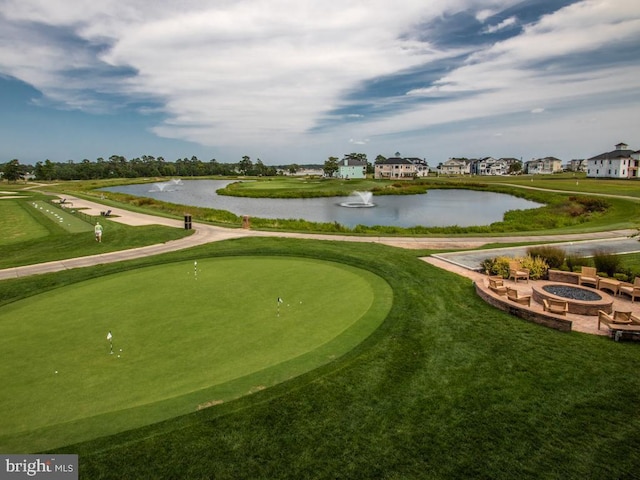 view of home's community with view of golf course, a water view, and an outdoor fire pit