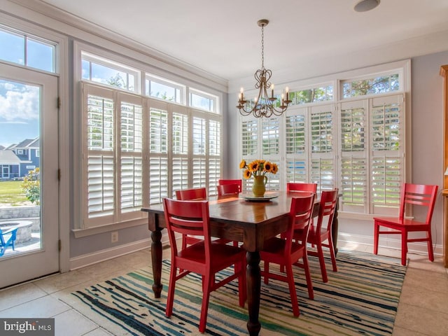 dining area with baseboards, a wealth of natural light, light tile patterned floors, and an inviting chandelier