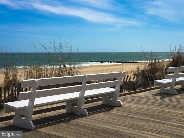 deck featuring a view of the beach and a water view