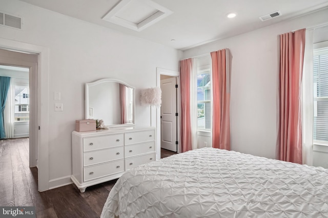 bedroom with visible vents, attic access, dark wood-style flooring, and baseboards