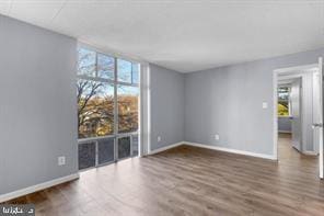 9201 New Hampshire Ave Unit 302, Silver Spring, MD 20903 - empty room featuring expansive windows, baseboards, and wood finished floors