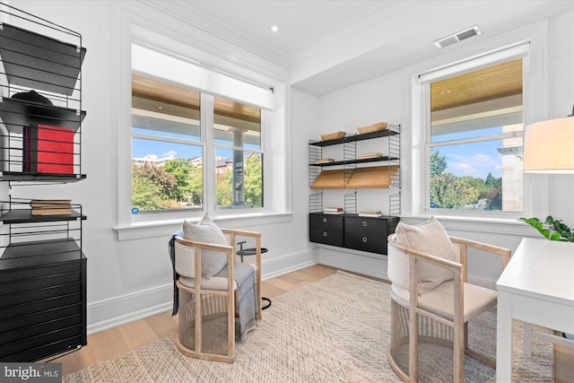 office space featuring baseboards, crown molding, wood finished floors, and visible vents
